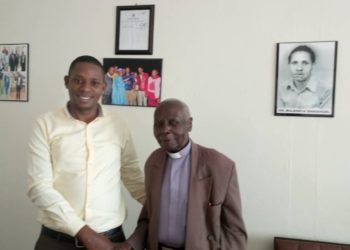 Rogers Bulegeya with Canon Njoji at his office located in Masaka Town.