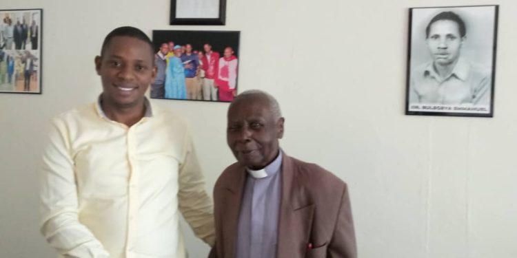 Rogers Bulegeya with Canon Njoji at his office located in Masaka Town.