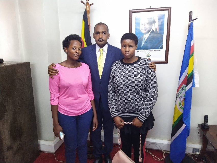 Gender Minister Frank Tumwebaze with Happy Atuhebirungi (R) and Molly Kayesu who returned from abusive empolyment in the Middle East on Tueday