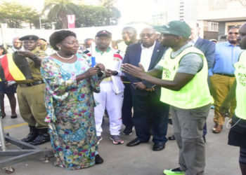 Kadaga (L) hands over a baton to one of the runners