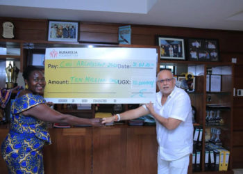 Dr Sudhir handing over a cheque to Ruth Nankabirwa