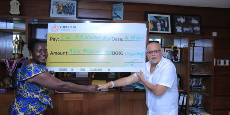 Dr Sudhir handing over a cheque to Ruth Nankabirwa