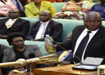 MP Abala holding a bottle containing locusts while in the House