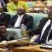 MP Abala holding a bottle containing locusts while in the House