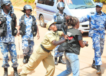 A police officer manhandling a journalist