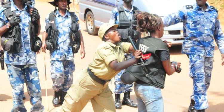 A police officer manhandling a journalist