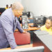 Minister-Chrysostom-Muyingo-engages-a-student-in-a-computer-lab.