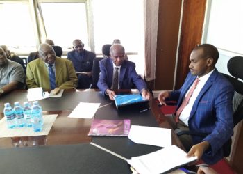 Prof. Vinand Mukatabala Nantulya (Left) handing over the petition to Hon. Frank Tumwebaze in Kampala.