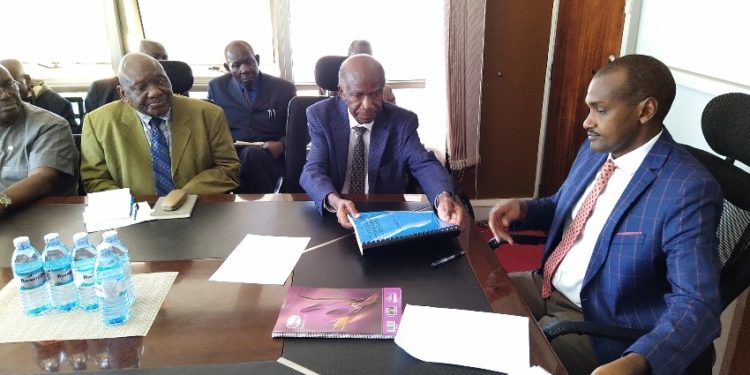 Prof. Vinand Mukatabala Nantulya (Left) handing over the petition to Hon. Frank Tumwebaze in Kampala.