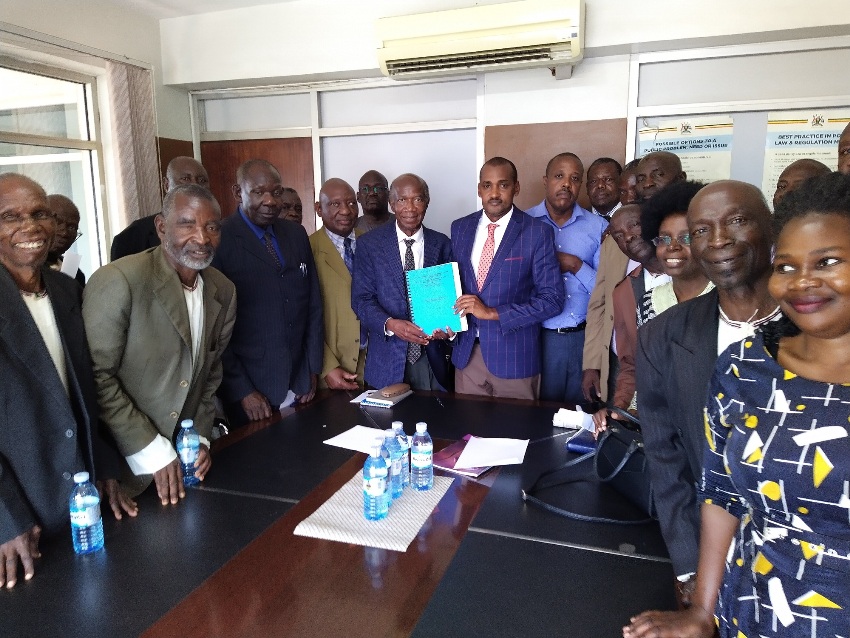 Prof. Vinand Mukatabala Nantulya (Left) handing over the petition to Hon. Frank Tumwebaze in Kampala