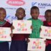 Pupils at Kiswa Primary School display the newly launched colour books