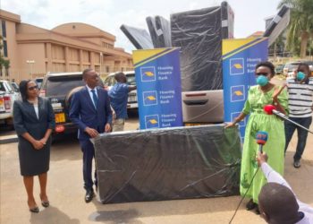 Health Minister Dr. Jane Ruth Aceng receives the donations from Housing Finance Bank Managing Director Micheal K. Mugabi and Executive Director Peace Kabunga