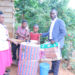 Dorothy Nakiryowa receiving donated items; Bed sheet and a blanket from Gideon Kabenge who is currently taking care of his brother Ssebaduka.