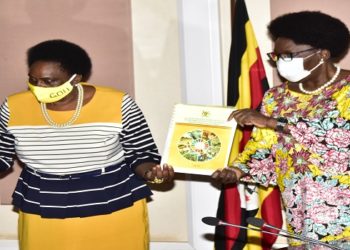 Minister Mary Karooro Okurut (left) hands over the SDGs report to the Speaker of Parliament Kadaga