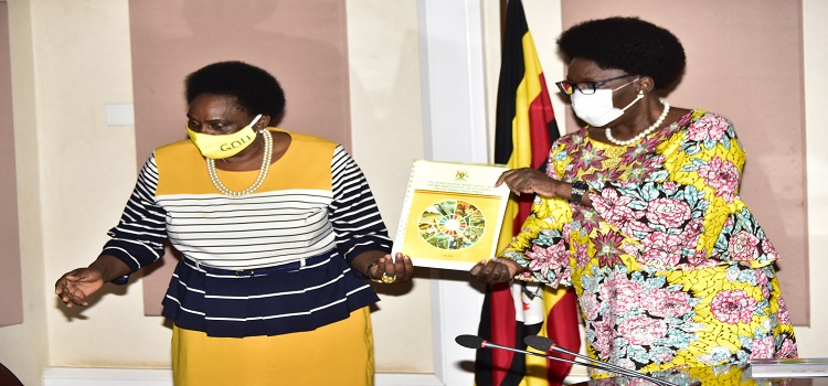 Minister Mary Karooro Okurut (left) hands over the SDGs report to the Speaker of Parliament Kadaga