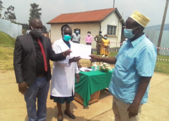  Bashir is receiving his covid-19 certificate from Darius Nandinda and the hospital director.