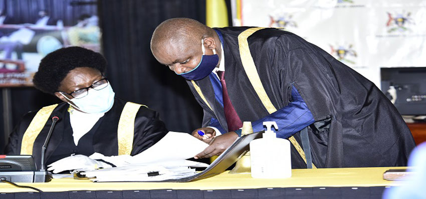 Speaker Kadaga(L) consults a clerk at Table during the debate on the NSSF Bill