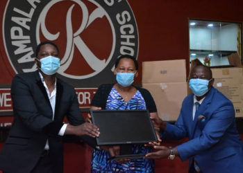 Mr Onyango Gareth, Mrs Daphine Kato handing over computers to Mr Solomon Serwanja