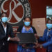 Mr Onyango Gareth, Mrs Daphine Kato handing over computers to Mr Solomon Serwanja