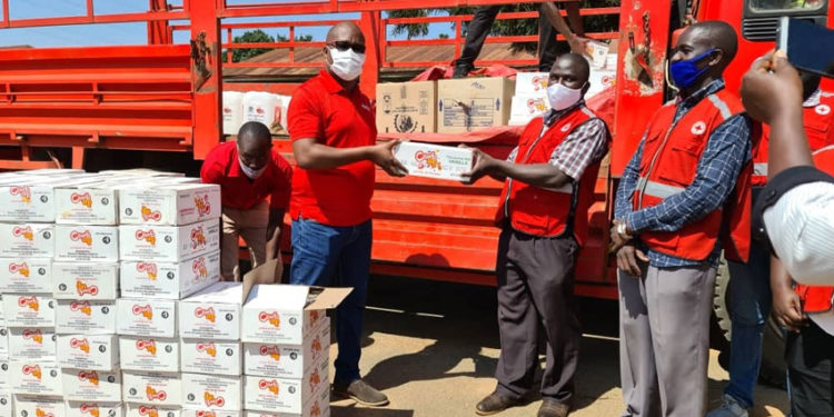 The Coca cola team led by Newton Lee Ogong, Events and Promotions Manager during the handover to Mukono Red Cross Society Manager Sam Mugisha