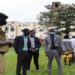 The LOP, Hon. Betty Aol Ocan (R), receiving a brief from a Police officer at Makerere University. In the background is the Main Building