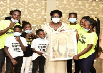 Speaker Rebecca Kadaga (C), the Clerk to Parliament, Jane Kibirige (left) and the Triplets Ghetto Kids, a dance group composed of children from the Katwe slum in Kampala district