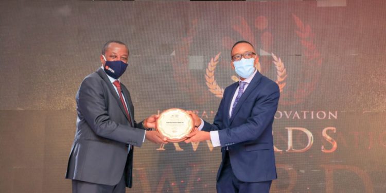 Uganda Insurers Association Chairman Latimar Mukasa hands over an award to a representative of one of the winners