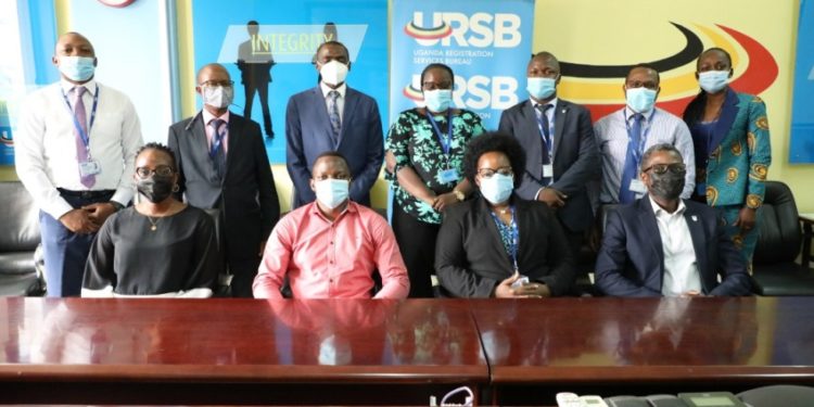 The Registrar General Mercy K.Kainobwisho (Seated 2nd R) & Tony Otoa the CEO Stanbic Business Incubator in a group photo after a meeting at the URSB Headquarters in Kampala.