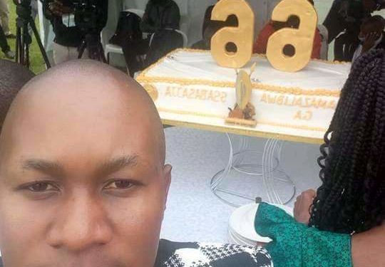 Kenneth Nsibambi and behind him is Kabaka's 66th birthday cake