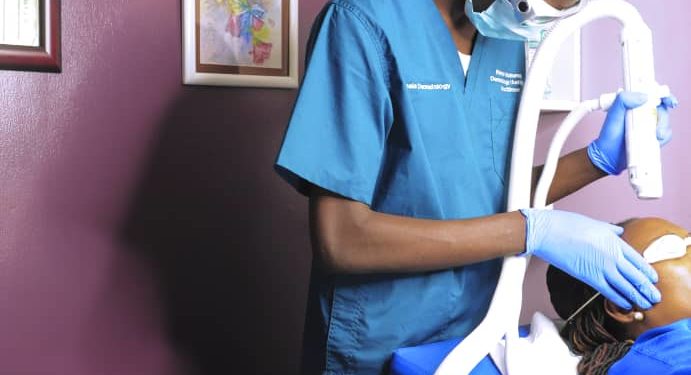 A Dermatologist at Kampala Dermatology clinic Bugolobi works on a patient using the specialised Aero lase Neo light Pod laser machine