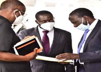 Finance Minister, Hon Matia Kasaija(R) interacts with his State Minister David Bahati(C) and Justice Minister, Ephraim Kamuntu before the start of the plenary sitting