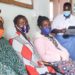 Anicia Filda in blue and white counsels women waiting for sterilisation at Atiak Health Centre IV