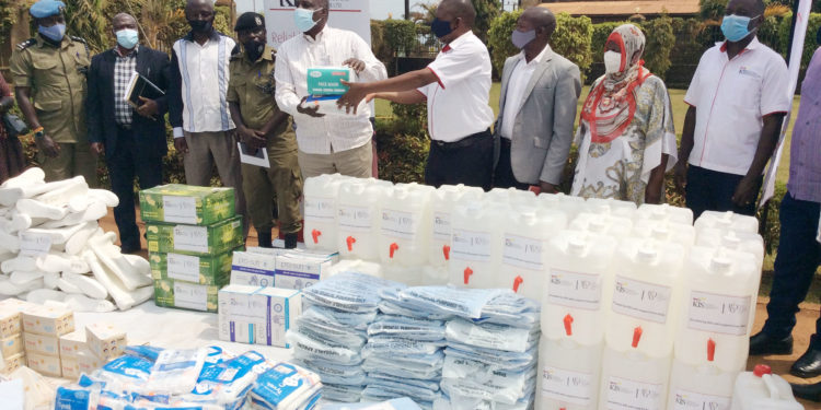 Kalangala Infrastructure Services (KIS) Marketing and Public Relations Manager Mr Joseph Mulindwa (4th right) hands over a donation of assorted infection prevention and control materials worth Shs32 million to the Chairman District Covid-19 Task Committee and RDC Kalangala, Mr Apollo Mugume recently