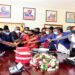 The LOP, Mathias Mpuuga (in red tie) cutting cake with colleagues to celebrate 100 days in office