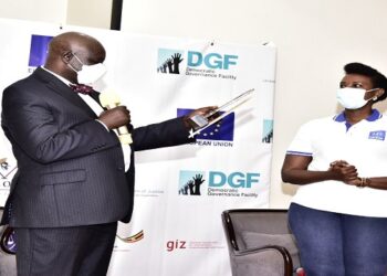 Oulanyah reads a citation before handing over an award to Sternford Moyo. Looking on is ULS President, Pheona Wall