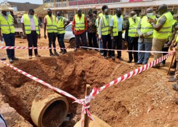The RCC Mbale, (In checked jacket) listens carefully to the Project Engineer during the site inspection visit on Naboa Road, Mbale City