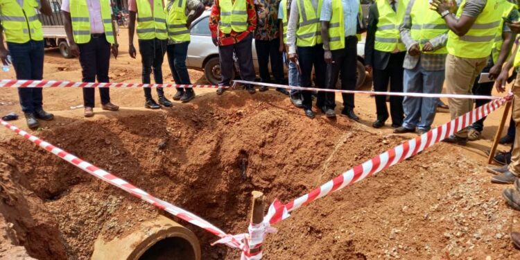 The RCC Mbale, (In checked jacket) listens carefully to the Project Engineer during the site inspection visit on Naboa Road, Mbale City