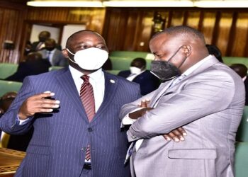 The LOP, Hon Mpuuga interacts with Minister Haruna Kasolo before the sitting of the House