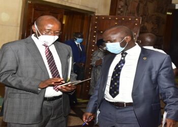 State Minister for Finance, Hon Lugoloobi(L) with Hon Ssekikubo after adjournment of the plenary sitting