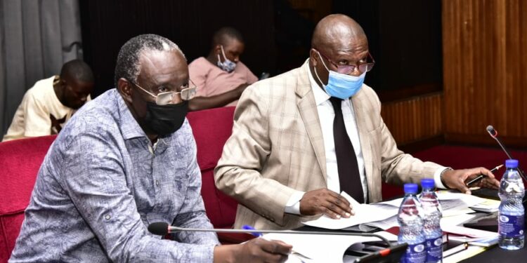 The Chairperson Budget Committee, Hon. Opolot Patrick Isiagi (left), interacting with the team from KCCA.