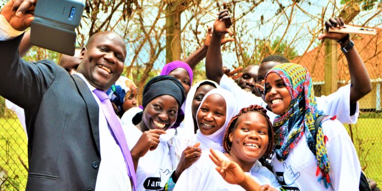 Jackson Chekweko RHU ED with children in Kamuli district