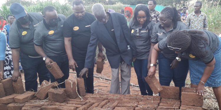 Uganda Airlines staff lay bricks to be used for Dhabangi's house construction