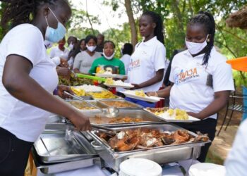 Invited guests being served delicious fish dishes