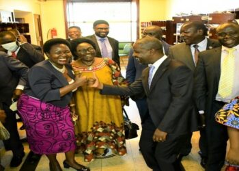 Nankabirwa and Tayebwa, accompanied by colleagues, fist bump to celebrate the passing of the EACOP Bill