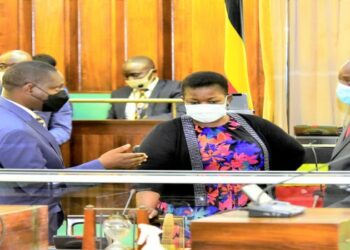 Ministers David Bahati (L) and Justine Kasule Lumumba, consulting with LOP Mathias Mpuuga after Parliament received the NBFP