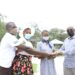 Brig Bakahumura hands over the envelope to Maximillah a student at Parental Care primary school Sanga in Kiruhura district. She is one of the beneficiaries of the annual school fees offer from Kigambira Safari Lodge, from the proceeds of the Kigambira Run attended by Champion Joshua Cheptegei on January 15 early this year. In the photo is Ali Seguya a Community assistant of Lake Mburo National Park and Ms Lynet, the mother of Maximillah.