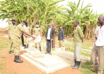 Police officers, PC Amos Kungu's relatives at the grave of the fallen officer