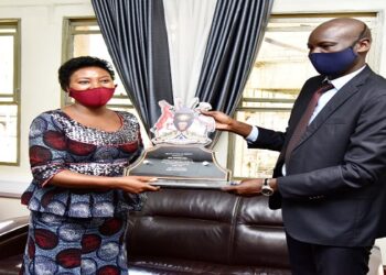 Hon Winnie Kiiza(L) receives her award from the Deputy Clerk