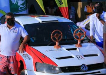 Rajiv (left) standing next to his rally car