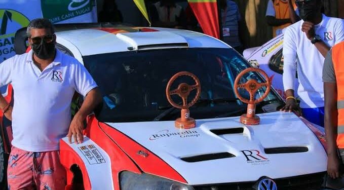 Rajiv (left) standing next to his rally car